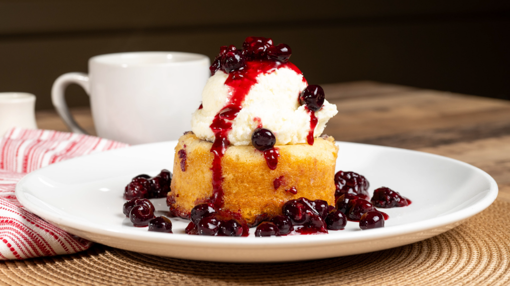 Warm berry cake topped with ice cream and berry sauce.