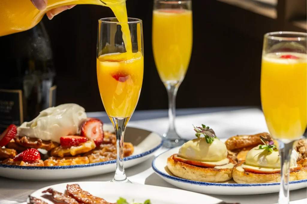 Mimosas served with waffles, strawberries and eggs benedict.