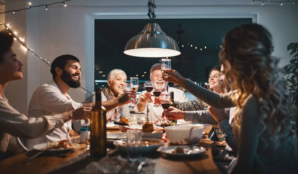 A group of people at the table holding drinks and dining with Bravo